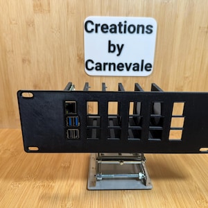 May include: Black metal rack with multiple slots and a panel with connectors. The rack is labeled "Creations by Carnevale".