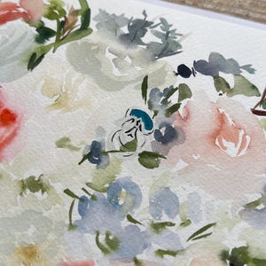 May include: A watercolor painting on textured paper featuring a floral arrangement with soft washes of peach, light blue, sage green, and white. The composition includes loose, blended petals and foliage with a small, distinct teal blue accent.