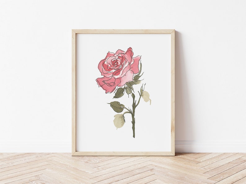 May include: A framed watercolor painting of a single pink rose with green leaves and stem on a white background.