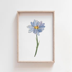 Può includere: Un dipinto ad acquerello incorniciato di un singolo fiore blu con un centro giallo. Il fiore è rappresentato in uno stile semplice e delicato.