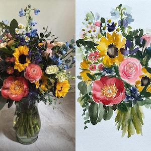 May include: A side-by-side comparison of a fresh floral bouquet in a clear glass vase and a watercolor painting of the same arrangement. The bouquet features yellow sunflowers, a pink ranunculus, a coral peony, blue delphiniums, and greenery.