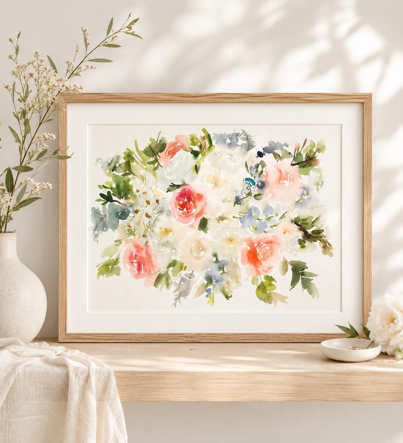 May include: A horizontal rectangular wooden frame containing a watercolor painting of a floral bouquet. The artwork features soft washes of coral, peach, white, and blue flowers interspersed with green foliage on a cream-colored background.