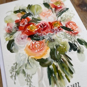 May include: A watercolor painting of a floral bouquet featuring red, orange, pink, and white flowers with green foliage. The artwork includes white paint splatters and the handwritten text "may 28, 2022" in black ink at the bottom right corner.