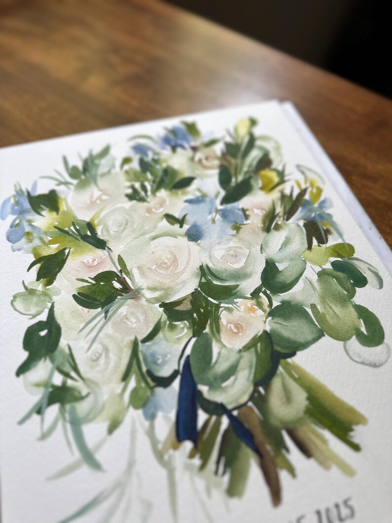 May include: A watercolor painting on white paper depicting a floral bouquet with white roses, green foliage, and light blue accents. The arrangement is tied with a dark blue ribbon at the base, featuring loose, expressive brushstrokes throughout.