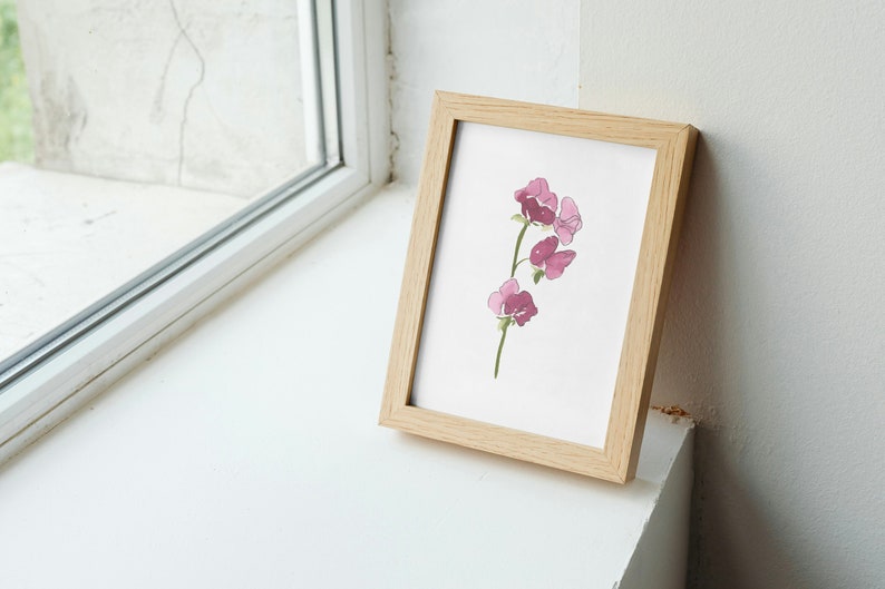 May include: A framed watercolor painting of a pink flower with a green stem. The painting is in a light wood frame.