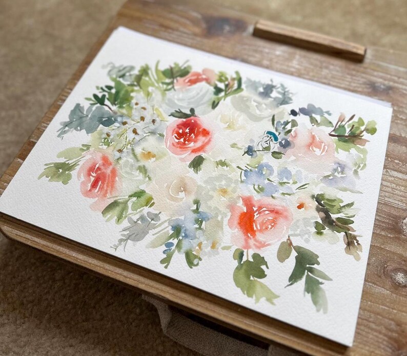 May include: A watercolor painting on white paper featuring a floral arrangement with coral, peach, and white blossoms. The composition includes various green leaves, stems, and small blue accents, rendered with soft, blended brushstrokes.