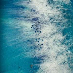 May include: Abstract artwork featuring a dynamic blend of blues and whites, reminiscent of ocean waves. The image showcases a fluid, textured design with varying shades of turquoise, navy, and white, creating a sense of depth and movement. The artwork evokes a coastal theme.