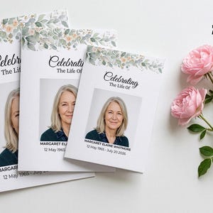 May include: Three white funeral program booklets featuring a floral border of green leaves and soft pink flowers. Each booklet displays the text Celebrating The Life Of, a photograph of a woman, and the name Margaret Elaine Whitmore with dates.