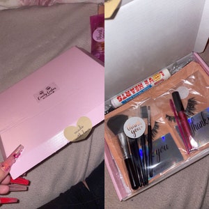 May include: Pink box with a sticker that says "Candy Corners by Candace" and a heart sticker that says "made with love". Inside the box is a smaller box with a peach-colored lining. The smaller box contains a set of makeup brushes, a tube of lip gloss, a pair of false eyelashes, and a small silver mirror with the words "Thank you" on it.
