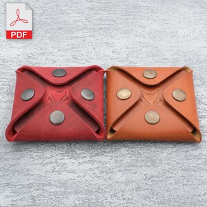 May include: Two leather coin purses, one red and one brown, with a fox logo embossed on the front. Each purse has four metal poppers.