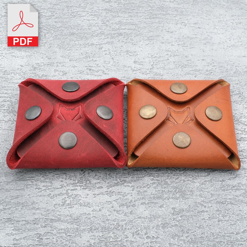 May include: Two leather coin purses, one red and one brown, with a fox logo embossed on the front. Each purse has four metal poppers.