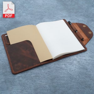 May include: A brown leather notebook cover with a pen holder and a flap that closes with a snap. The cover has a pocket on the front and a lined notebook inside.