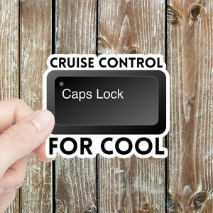 May include: A white sticker with black text that reads "Cruise Control Caps Lock For Cool". The sticker features a black computer key with the text "Caps Lock" on it.