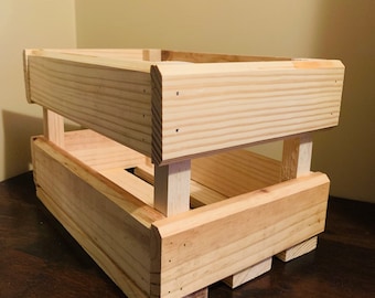 Peut inclure: Une caisse en bois naturel au design simple. La caisse est en bois de pin non fini et a une forme rectangulaire. Elle a un seul séparateur au milieu, créant deux compartiments.