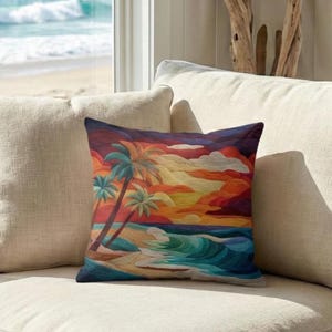May include: A decorative square pillow featuring a vibrant beach scene. The pillow displays a sunset with palm trees, waves, and a sandy shore. The color palette includes shades of orange, yellow, blue, and purple. The pillow is placed on a beige sofa.