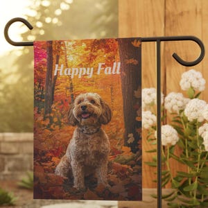 Puede incluir: Bandera de jardín con un perro sonriente en un bosque otoñal. El texto "Happy Fall" está en blanco. El fondo muestra hojas y árboles de colores otoñales, creando un ambiente cálido y estacional.