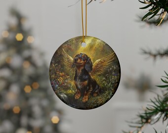 May include: A round ceramic ornament featuring a dachshund with angel wings. The dog is brown and black with a white chest and is sitting in a field of flowers. The background is a soft golden glow.