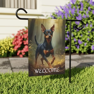 May include: A welcome garden flag featuring a black and tan miniature pinscher dog running through a forest scene. The flag has the word "welcome" printed on the bottom.