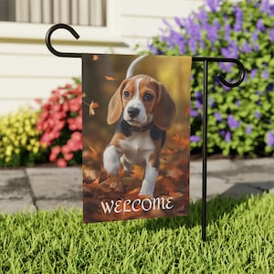 May include: A welcome garden flag featuring a beagle puppy running through autumn leaves. The flag is brown and white with the word "welcome" printed in white.