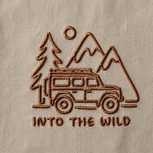 May include: A beige fabric surface featuring a brown embroidered design of a pine tree, a sun, mountains, and an off-road vehicle. Below the illustration, the text "INTO THE WILD" is embroidered in a matching brown thread in a simple font.