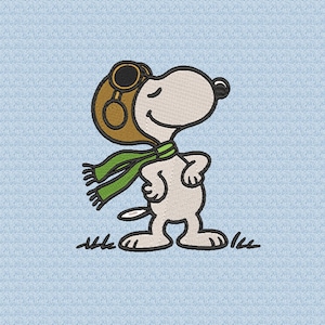 May include: An embroidered image of Snoopy, the cartoon beagle, wearing a brown aviator helmet and a green scarf. Snoopy is standing on a light blue background with blades of grass at his feet.