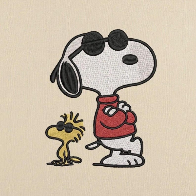 May include: Embroidered image of Snoopy and Woodstock wearing sunglasses. Snoopy is in a red sweater, arms crossed. Woodstock is yellow. The background is a light beige color.