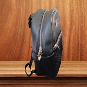 May include: A black leather backpack with a quilted design and gold accents. The backpack has a zipper closure and a top handle.