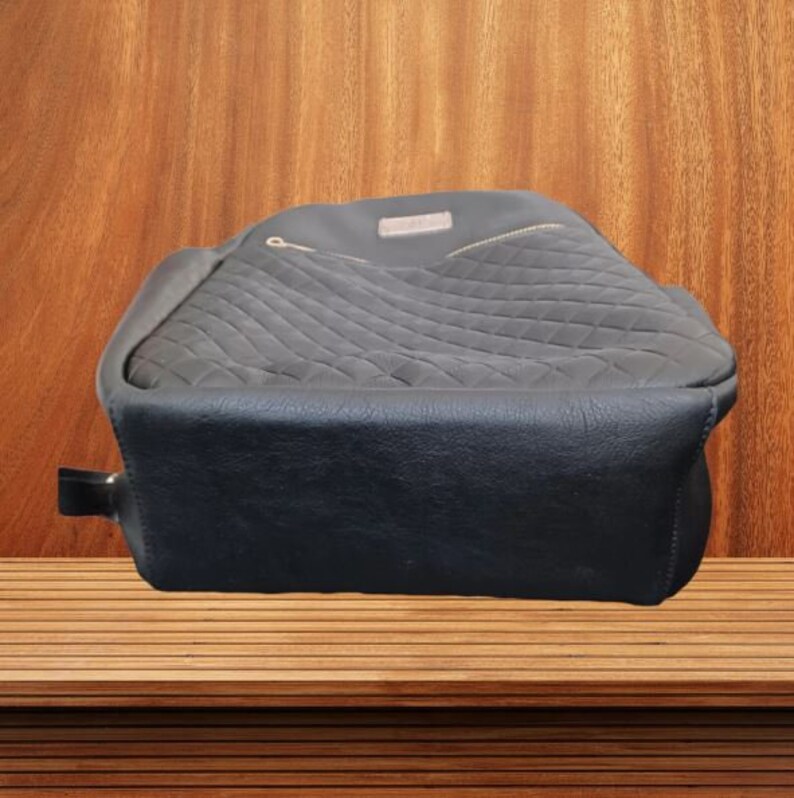 May include: A black quilted backpack with a zippered pocket and a gold zipper pull.