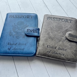 May include: Two rectangular passport holders, one blue and one grey, each featuring the embossed United States of America seal, the word PASSPORT, and a magnetic closure strap personalized with the names Evin and Jimmy respectively.