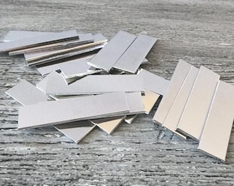 1/2 x 1-3/4" (10) 16g Aluminium 1100 Prostokąty Średnio temperowane Czyste aluminium Polerowane bębnowo Bez otworów Gotowe do stemplowania Płaskie półfabrykaty