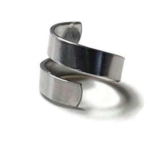 May include: A silver spiral ring made of two bands of metal twisted together.