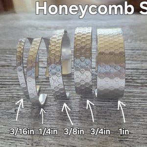 May include: Silver and gold-toned metal bracelets with a honeycomb pattern. The bracelets vary in width from 0.5 cm to 2.5 cm. The image includes the text "Honeycomb Sm".