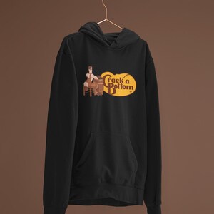 May include: Black hooded sweatshirt with a front pocket and a graphic that reads "Crack a Bottom" in a yellow oval. The graphic features a cartoon of a person sitting on a barrel. The Werkroom logo is visible on the bottom left.