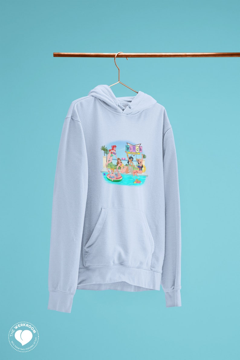 Może przedstawiać: Jasnoniebieska bluza z kapturem z grafiką przedstawiającą imprezę przy basenie. Ilustracja przedstawia kobiety w strojach kąpielowych przy basenie, z napisem "Bitch" na znaku. Bluza ma kieszeń typu kangur i kaptur ze sznurkiem.