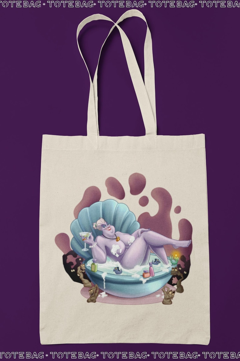 May include: Off-white tote bag featuring a cartoon illustration of a purple character relaxing in a seashell bathtub, holding a cocktail. The design includes a purple and blue color scheme, with the words "TOTE BAG" at the top and bottom.