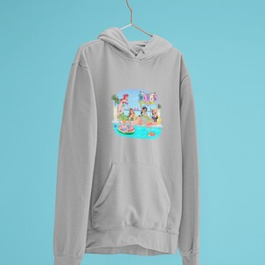 Może przedstawiać: Jasnoszara bluza z kapturem z przednią kieszenią i kapturem ze sznurkiem. Grafika z przodu przedstawia scenę przy basenie z kobietami, palmami i napisem "Bitch". Bluza z kapturem wisi na złotym wieszaku na niebieskim tle.