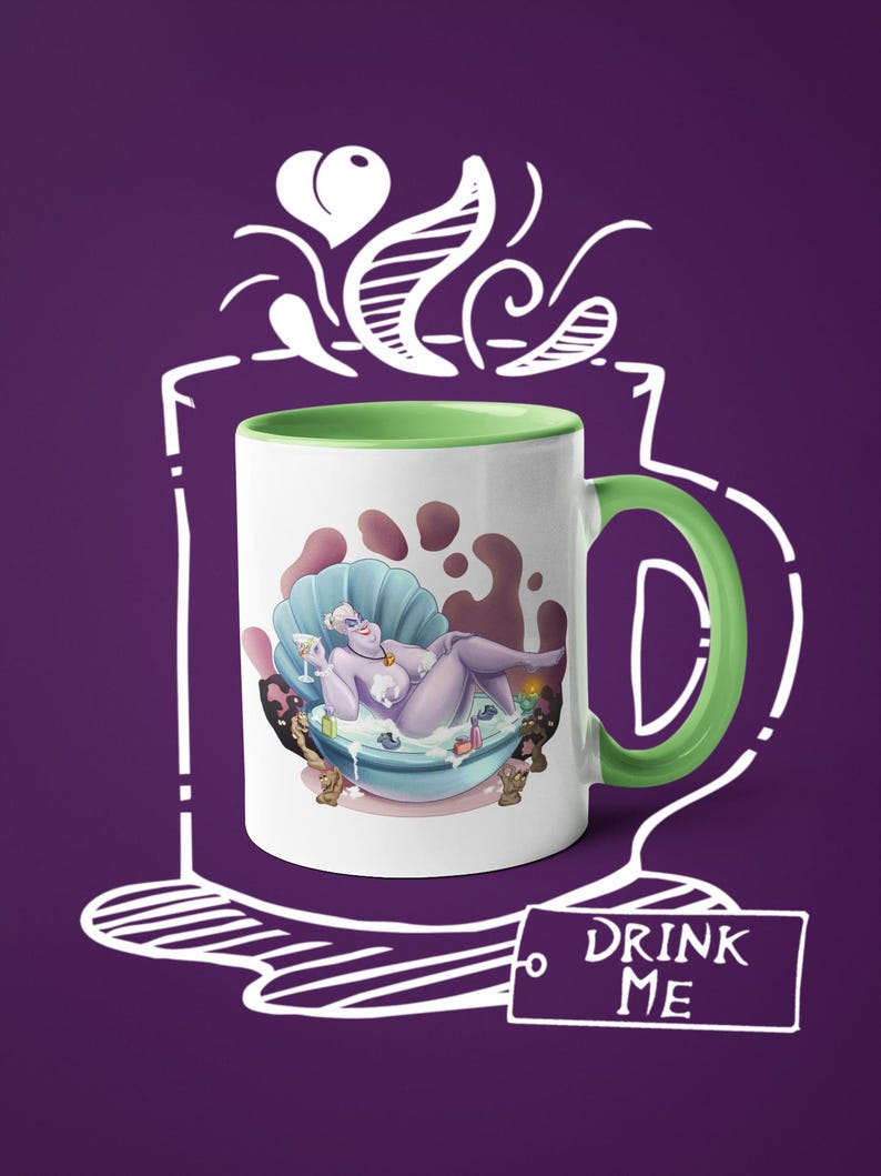 May include: White ceramic mug with a green handle and interior. The mug features a cartoon illustration of a purple character in a seashell bathtub, holding a drink. The text "DRINK ME" is on a tag attached to the mug.