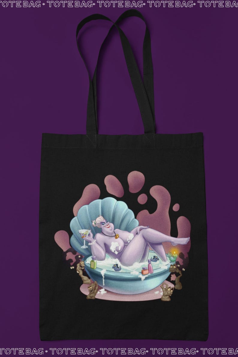 May include: Black tote bag featuring a cartoon illustration of a purple character relaxing in a seashell bathtub. The character is holding a cocktail. The background has pink and purple accents. The tote bag has black handles.
