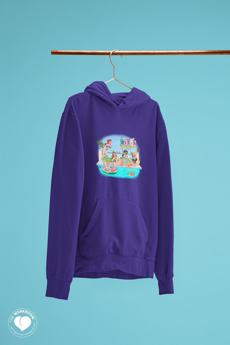 Może przedstawiać: Fioletowa bluza z kapturem z nadrukiem na przodzie przedstawiającym scenę przy basenie z kobietami, basenem i napisem "Beach". Bluza ma kaptur i przednią kieszeń. Tło jest jasnoniebieskie.
