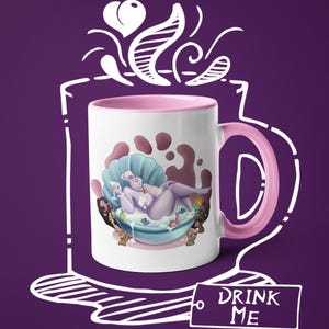 May include: White ceramic mug with a pink interior and handle. The mug features a cartoon illustration of a purple character in a seashell bathtub. The words "DRINK ME" are on a tag attached to the mug.