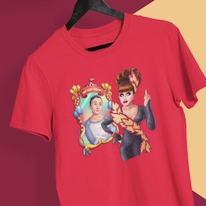 May include: Red t-shirt with a graphic of a drag queen in a black dress and a man in a blue shirt looking in a mirror with a circus theme.