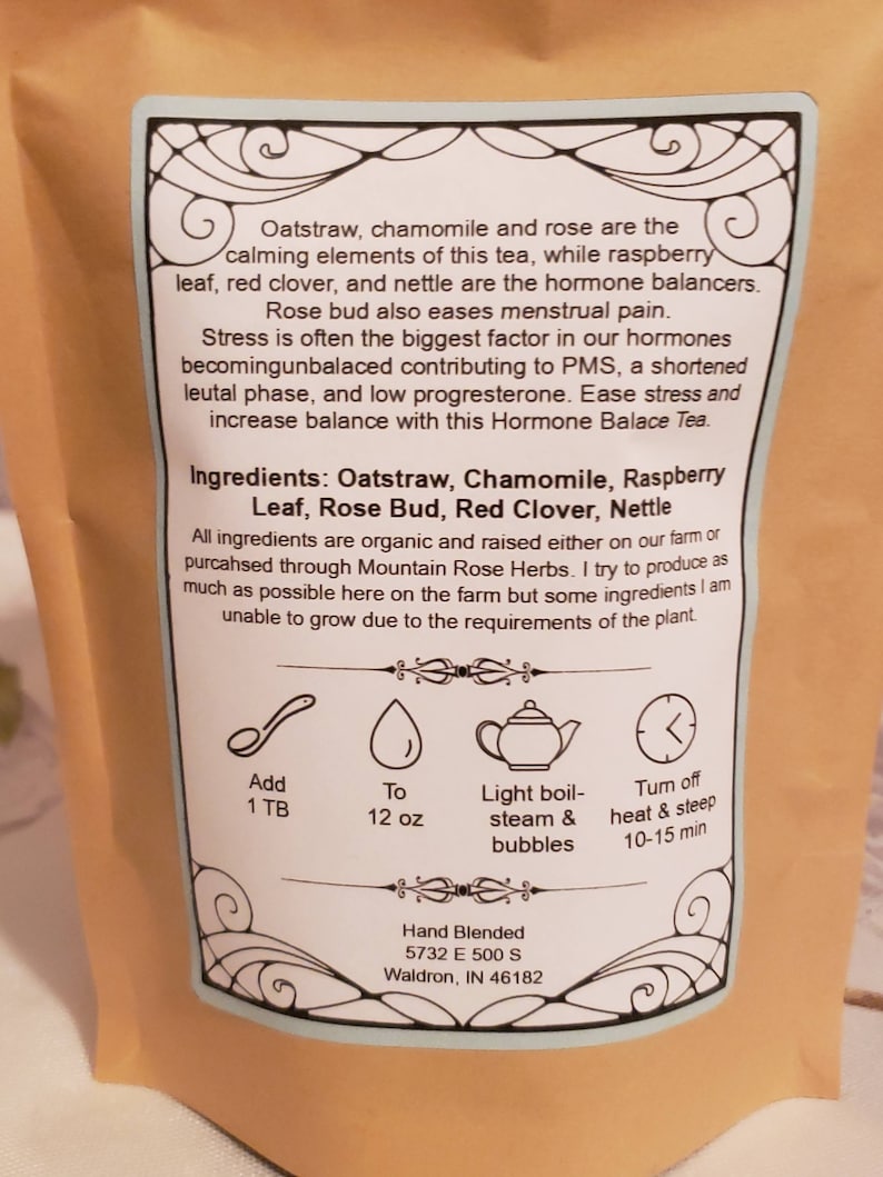 May include: A blue and white label with a floral design. The label lists the ingredients of a tea blend: Oatstraw, Chamomile, Raspberry Leaf, Rose Bud, Red Clover, and Nettle. The label also includes instructions for brewing the tea: add 1 tablespoon of tea to 12 ounces of water, bring to a light boil, and steep for 10-15 minutes.