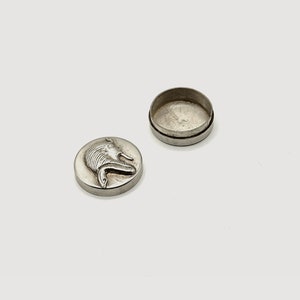 以下が含まれることがあります： 蓋にエジプトのスフィンクスのレリーフが施された銀製のピルボックスです。