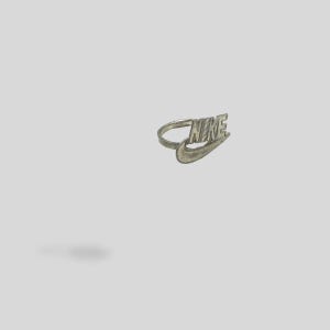 以下が含まれることがあります： ナイキのロゴと「NIKE」という文字が刻印された銀のリングです。