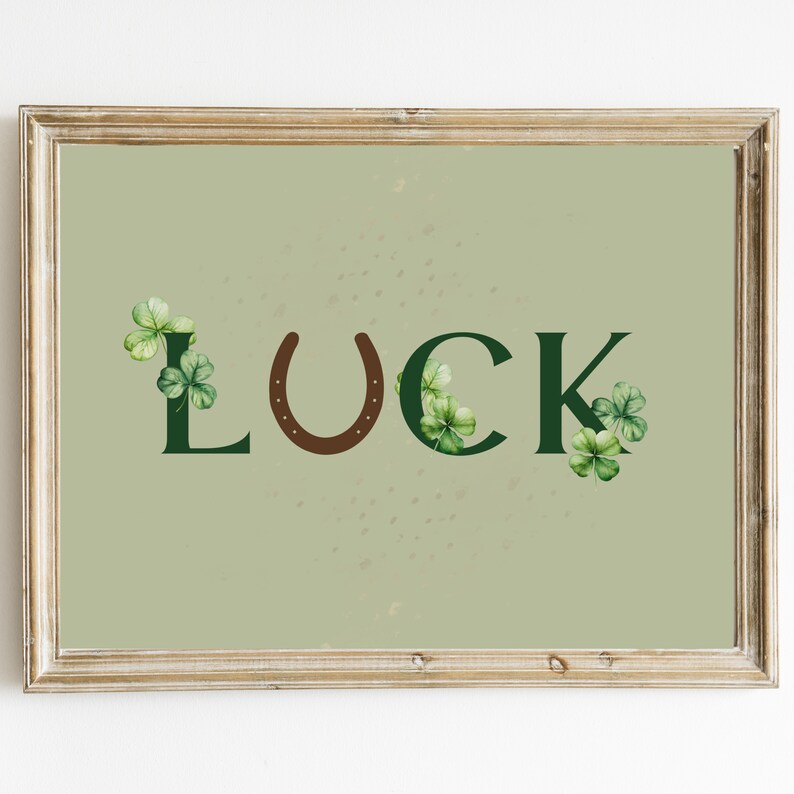 May include: A framed print with a green background and the word "LUCK" in green letters with a brown horseshoe in between the "U" and "C".  There are green shamrocks around the letters.
