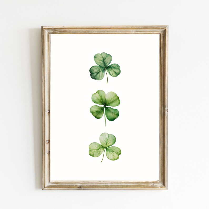 May include: A framed print of three watercolor shamrocks, each with four green leaves, arranged vertically in a row.
