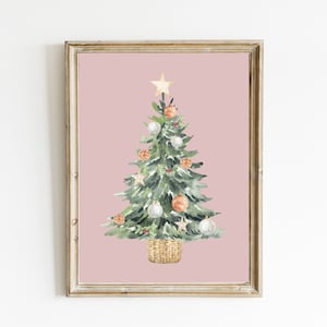K&ouml;nnte beinhalten: Ein Aquarellbild eines Weihnachtsbaums vor rosa Hintergrund. Der Baum ist mit wei&szlig;en und orangen Kugeln, einem goldenen Stern oben und einem braunen Weidenkorb am Fu&szlig; geschm&uuml;ckt.