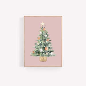 K&ouml;nnte beinhalten: Ein Aquarellbild eines Weihnachtsbaums vor rosa Hintergrund. Der Baum ist mit wei&szlig;en und orangefarbenen Kugeln, einem goldenen Stern oben und einem braunen Weidenkorb an der Basis geschm&uuml;ckt.