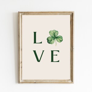 May include: A framed print with a green shamrock and the word "LOVE" in green text.