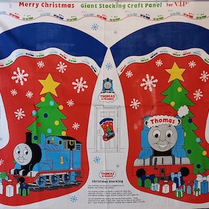 May include: A red and white Christmas stocking craft panel featuring Thomas the Tank Engine. The panel includes images of Thomas, Christmas trees, snowflakes, and the text "Merry Christmas" and "Thomas & Friends".